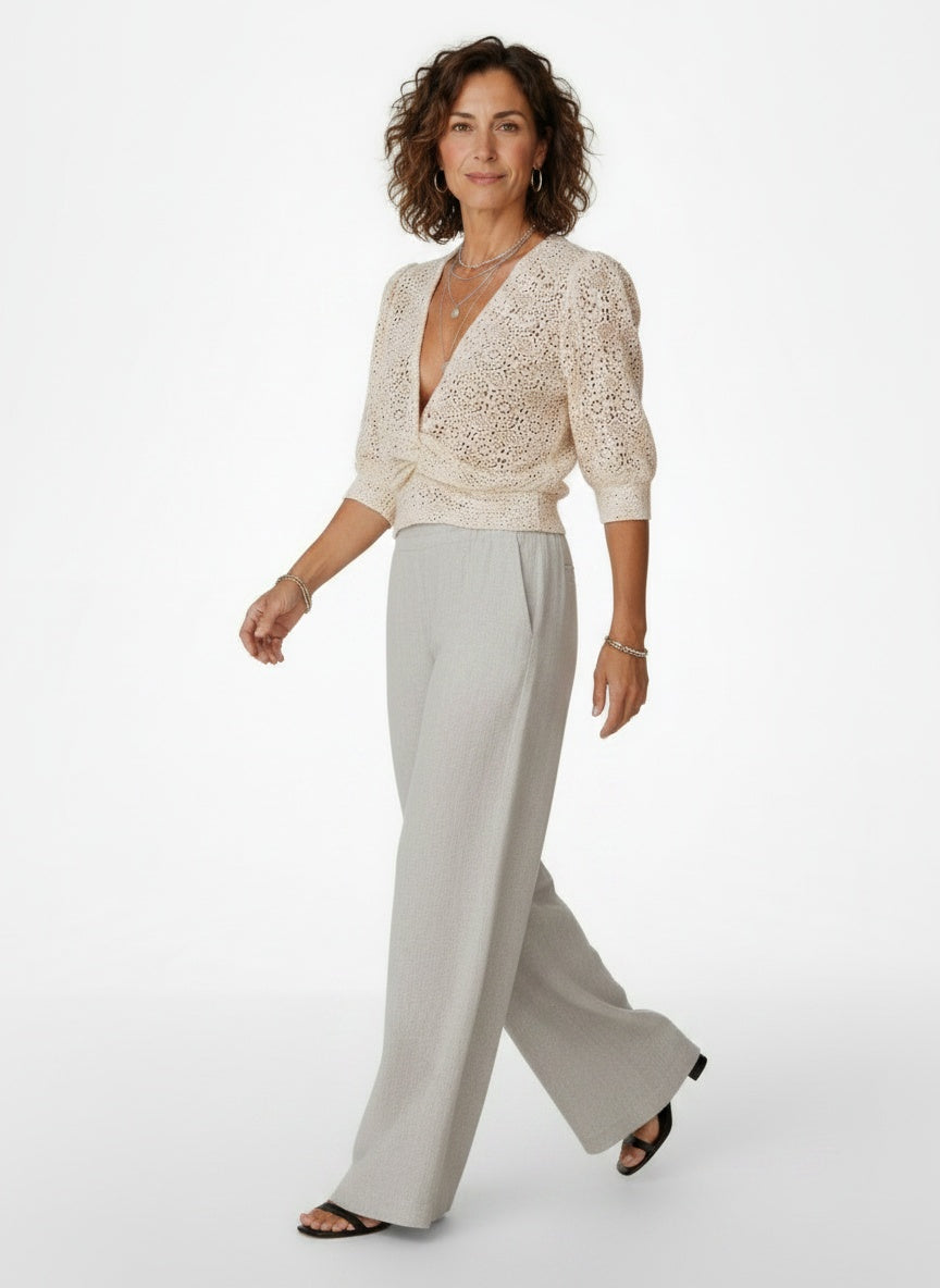 Model walking while wearing Kanten Blouse met Knoopdetail