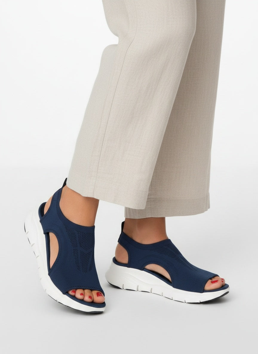 Close-up lower legs and shoes of the model wearing Sportieve Instap-sandaal met Gebreide Sok