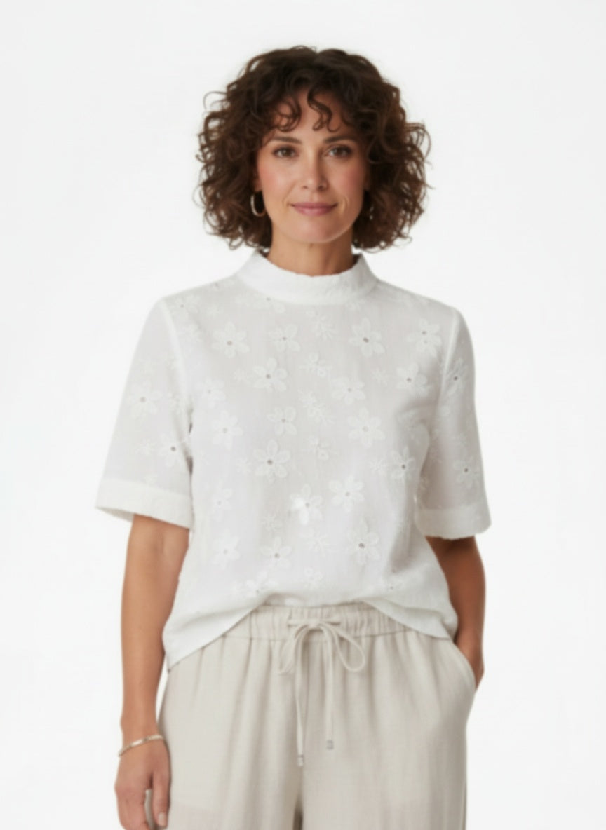 Full body view of the model wearing Witte Broderie Blouse met Opstaande Kraag
