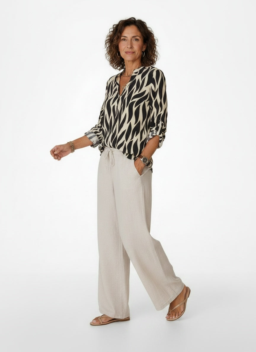 Model walking while wearing Oversized Blouse met Grafische Print