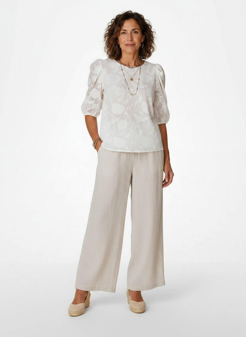 Full body view of the model wearing Jacquard Blouse met Bloemenprint en Pofmouwen