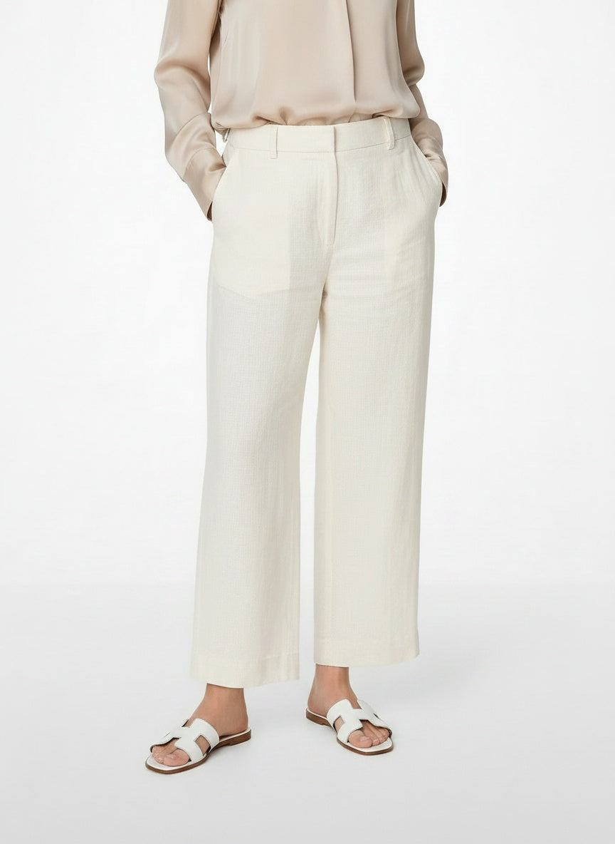 Close-up lower legs and shoes of the model wearing Leren Slippers met Iconisch H-Motief